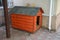 Wooden doghouse  inthe yard. Wooden dog house near house wall for home protection