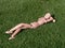 Wooden doll lying on the grass relaxed sunbathing