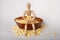 Wooden doll sitting popcorn in arms large bowl of popped corn kernels