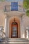 Wooden door with arched transom window below the balcony with double door at San Francisco, CA