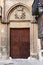 Wooden door beneath a heraldic shield