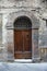 Wooden door with brick archway.