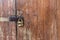 Wooden door with lock. Lock on an old wooden gate. Old padlock on closed doors.