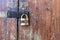 Wooden door with lock. Lock on an old wooden gate. Old padlock on closed doors.