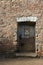 Wooden door with old `castrol` sign surrounded by nice brickwork