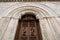 Wooden door and portal in light marble carved of the Cathedral of San Feliciano in Foligno