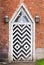 Wooden door in red brick wall, Gothic Revival