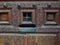 Wooden door with a rusty metal mailbox and a peephole.