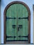 Wooden double barn door with rounded corners. Wooden plank door with forged metal parts