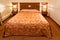 Wooden double bed with bedside tables in cozy stylish hotel room