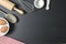 Wooden dough roller, bowl, measuring cups and whisk on the black table