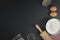 Wooden dough roller, a cup of flour, eggs and whisk on the black table