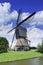 Wooden drainage windmill in a polder with a blue sky and dramatic clouds, Netherlands