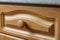 Wooden drawer of a kitchen unit with a round wooden handle