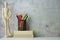 A wooden drawing figure stands next to the books on which crayons are built