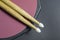 wooden drum sticks lying on a training peda and on a black background