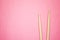 Wooden drumsticks on pink back