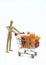 Wooden dummy carries shopping cart with bottles of pills, insulated on white background