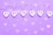 Wooden eart-shaped harland on purple background. Greeting card for st valentine`s day, Copy space