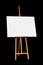 Wooden Easel with Blank Painting Canvas Isolated on Black Background