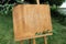 Wooden easel with a board. On the board written white paint - Welcome