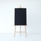 Wooden easel with empty black canvas. 3d rendering