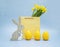 Wooden Easter Bunny with yellow candles of eggs shape, paper package, narcissus flower on