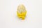 Wooden egg in yellow crocheted stand isolated on white background. Easter zero waste