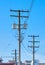 Wooden electricty pole with mounted transformators on blue sky background