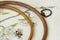 Wooden embroidery hoop with fragment of colorful cross-stitch embroidery close-up, summer flower ornament