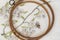 Wooden embroidery hoop with fragment of a colorful cross-stitch embroidery, flower ornament