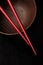 Wooden empty bowl and chopsticks on black table