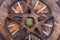 Wooden encircled Pentagram symbol with Unakite stone in the middle of a circle made of colorful parrot feathers. Five elements