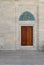 Wooden engraved door on stone wall and tiled marble floor