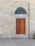 Wooden engraved door on stone wall and tiled marble floor