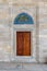 Wooden engraved door on stone wall and tiled marble floor, Sulaymaniye Mosque, Istanbul