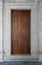 Wooden engraved door on white marble wall