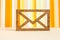 Wooden envelope icon on orange striped background