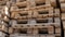 Wooden euro pallets for transfering goods to customers. Used wooden pallets in stack in the warehouse. Wooden pallet