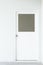 Wooden factory office door with square window on white wall background, real empty interior frame for residental house or business