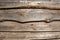 Wooden faded old brown planking background with cracks and splits