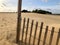 Wooden fence with blue skies and clouds at the sand dunes