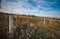 Wooden fence countryside green field wheat white clouds blue sky