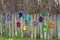 Wooden fence with decorative elements in the form of multicolored stylized birdhouses. Colored decorative birdhouses on a picket