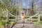 Wooden fence and gate surrounded by greenery with the ruins of a WWII bunker in the background