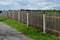 Wooden fence made of natural planks. the columns are made of roughly worked gray granite. fencing land in the mountains. meadow tr