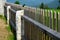Wooden fence made of natural planks. the columns are made of roughly worked gray granite. fencing land in the mountains. meadow tr