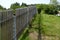 Wooden fence made of natural planks. the columns are made of roughly worked gray granite. fencing land in the mountains. meadow tr