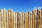 Wooden fence made of sharpened planed logs.