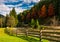 Wooden fence near forest river in autumn mountains